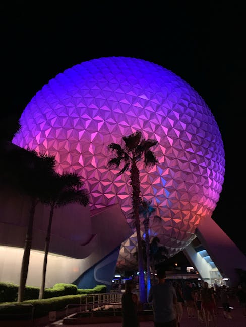 Colorful night view of Epcot's geodesic sphere with illuminated architectural design.